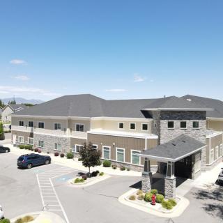 Aerial view of a commercial building with adjacent parking lot under a clear blue sky.