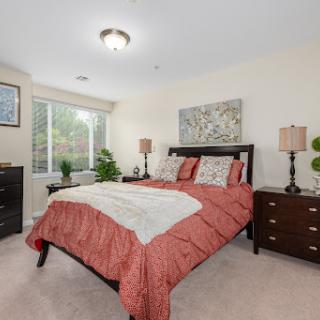 A cozy and well-decorated bedroom featuring warm colors and natural light.