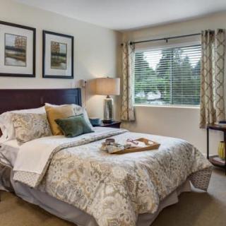 A cozy bedroom with elegant decor and a large window.