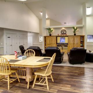 A spacious living room with a dining table, comfortable seating, and an entertainment center.