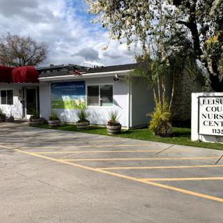A modern surgery center surrounded by greenery, featuring clear signage and a welcoming entrance.