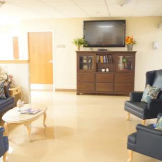 A cozy living room with comfortable seating, a cabinet with a TV on top, and a coffee table.