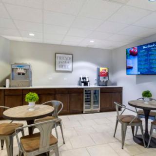 A modern break room with tables, chairs, and a beverage station.
