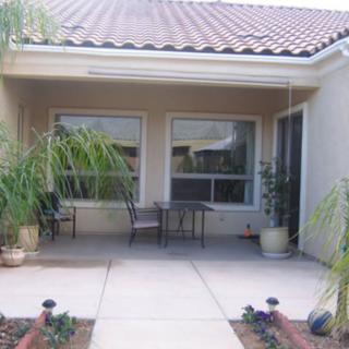 A residential patio with outdoor seating and potted plants.