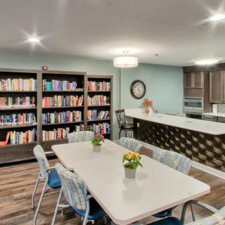 A cozy library with a dining area and bookshelves.