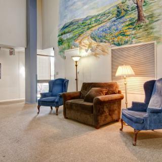 A cozy living room with armchairs and a vibrant mural.