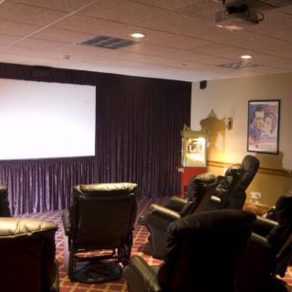 A cozy home theater setup with recliner chairs and a large projector screen.