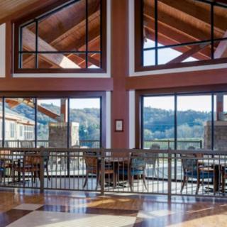 A spacious and well-lit restaurant interior with large windows offering a scenic view.