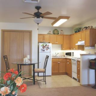 A cozy kitchen with wooden cabinets, a dining area, and a variety of appliances.