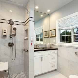 A modern bathroom featuring a walk-in shower and a stylish vanity with a large mirror.