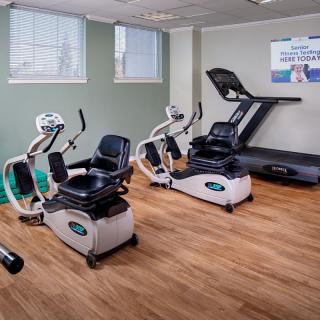 A fitness room equipped with a treadmill and stationary bikes.
