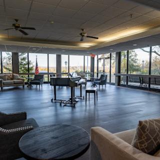 A bright and modern lounge area featuring comfortable seating and large windows that invite natural light.