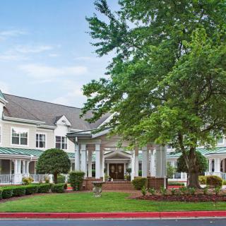 A well-maintained residential building with a landscaped entrance and lush trees.