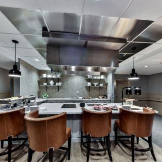 A modern kitchen with stainless steel accents and bar seating.