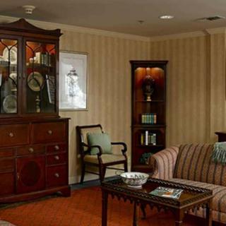 A traditional living room with elegant furnishings, including a cabinet and a striped sofa.
