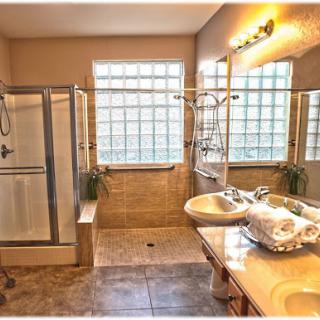 A modern bathroom featuring a spacious shower, double sinks, and ample natural light.