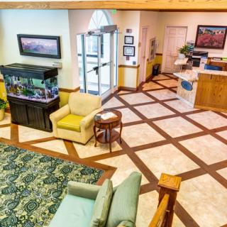 A bright and welcoming lobby with an aquarium, cozy seating area, and reception desk.