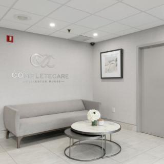 A modern and minimalist lobby featuring a gray sofa and a round coffee table.