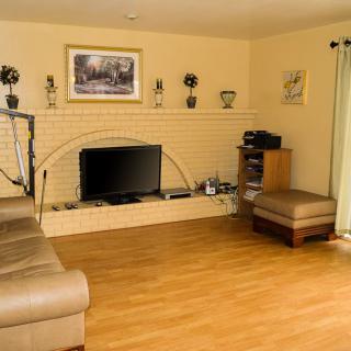 A cozy living room with a television and fireplace, featuring a comfortable couch and stylish decor.
