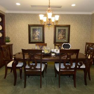 A beautifully decorated dining room featuring a large table, elegant chairs, and a chandelier.