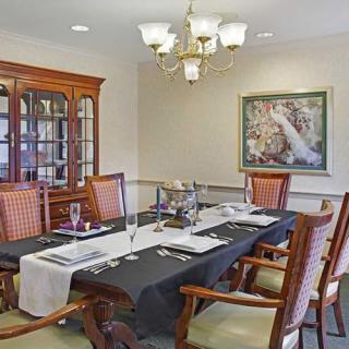 A well-decorated dining room with a large table, elegant chairs, and a chandelier.