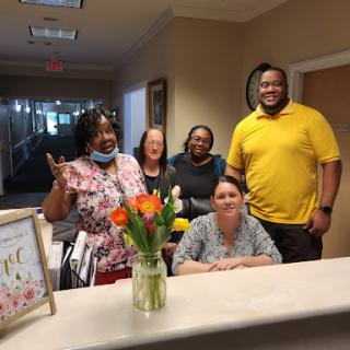 A cheerful team at the reception desk, showcasing camaraderie and positivity in the workplace.