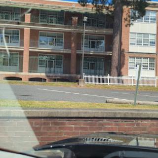 A view of a school building from a parked car.
