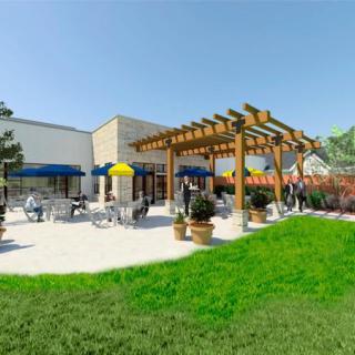 A sunny patio area with a pergola and outdoor seating, surrounded by well-maintained landscaping.
