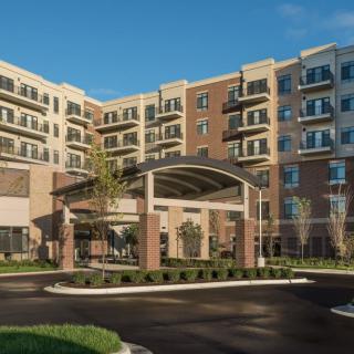 Modern apartment building with a welcoming entrance and landscaped surroundings.