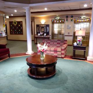 A cozy lobby area featuring comfortable seating, a reception desk, and decorative elements.