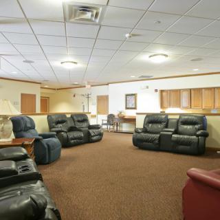 A comfortable lounge area with several recliner chairs arranged on a carpeted floor.