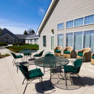 Outdoor patio area with tables and chairs on a sunny day.