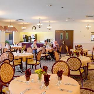 A spacious dining room with elegantly set tables and chairs, ready for guests.