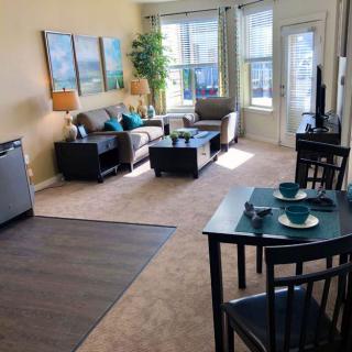 A cozy apartment living room with a dining area, featuring modern furniture and ample natural light.