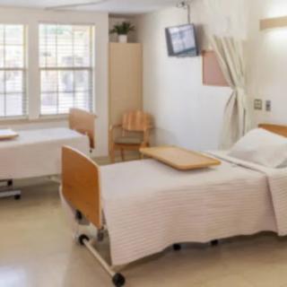 A hospital room with two beds and medical equipment.