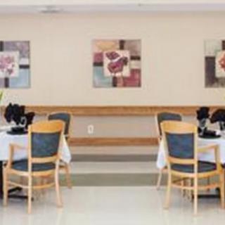 A dining area with neatly arranged tables and chairs, adorned with artwork on the walls.