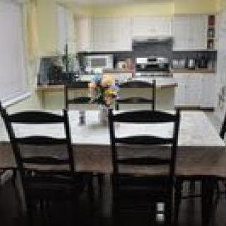 A cozy kitchen and dining area with a table set for six, surrounded by modern appliances.