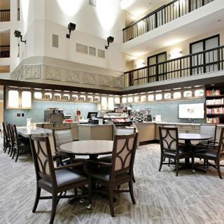 A spacious cafe interior with modern furnishings and ample seating.