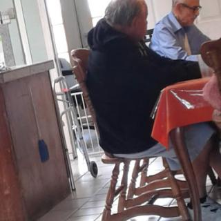 Two men engaged in conversation at a casual dining establishment.