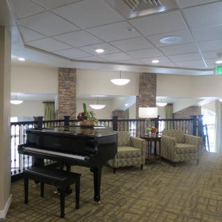 A spacious lobby area featuring a grand piano and comfortable seating arrangements.