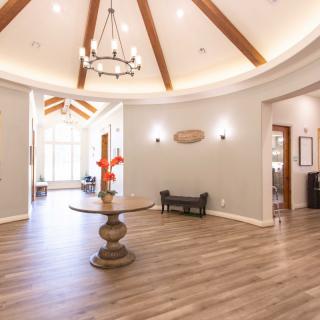 A spacious and elegantly designed lobby with a chandelier and wooden beams.