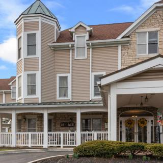 A charming residential building with a porch and tower-like structure.