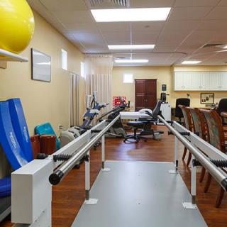 A rehabilitation center with various exercise equipment for physical therapy.