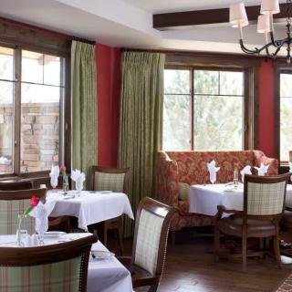 A cozy restaurant dining area with elegantly set tables and comfortable seating.