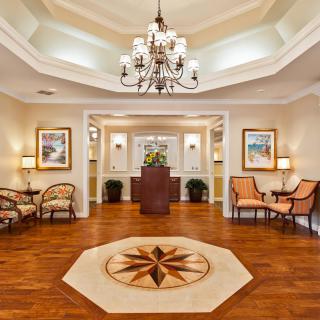 A luxurious lobby featuring a chandelier, seating areas, and elegant artwork.