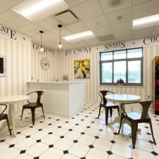 A cozy cafe interior with striped walls, small tables, and chairs.