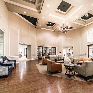 A luxurious and spacious living room with elegant seating arrangements and a sophisticated chandelier.