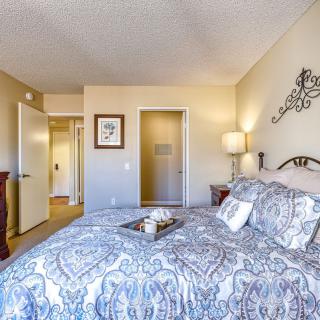 A cozy bedroom with elegant bedding and warm lighting.