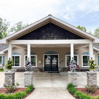 A modern entryway featuring a beautifully designed house with landscaped surroundings.