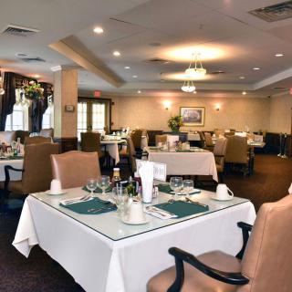 An elegant restaurant dining room with neatly arranged tables and chairs.